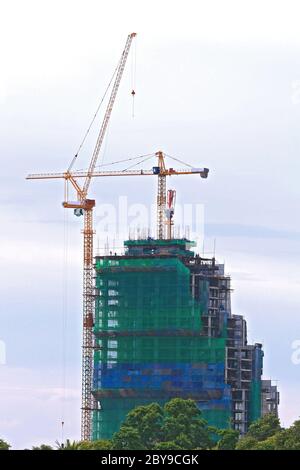 Skyscraper Office Tower Under Construction with two Cranes in Pattaya Thailand Stock Photo