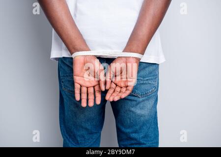 Rear behind view cropped closeup photo of dark skin african guy tied with rope arms police took his freedom thief professional criminal don't have Stock Photo