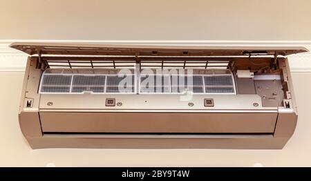 Gold air conditioner on the wall in room. Stock Photo