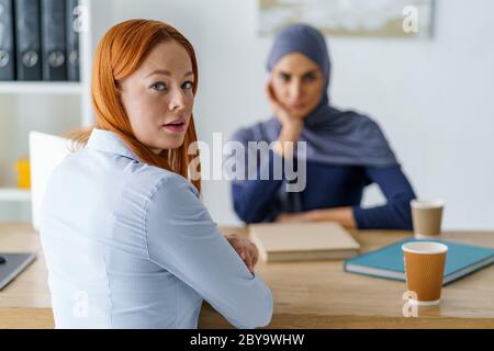 Stressed woman having an interview, sitting in HR's office and looking over Stock Photo