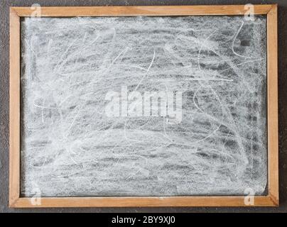 Blank chalkboard stained with chalk in wooden frame. Stock Photo