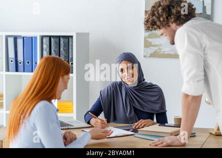 Female Muslim boss discussing a project with her employees Stock Photo