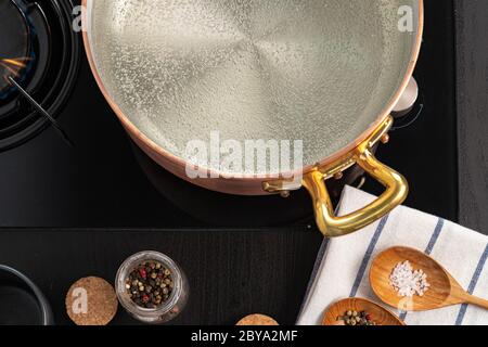 Copper pot with boiling water on a gas stove Stock Photo