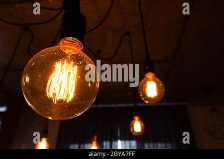 Big vintage incandescent light bulbs hanging in modern kitchen. Decorative antique edison light bulbs with straight wire. Dimmable, warm white, E27 Stock Photo