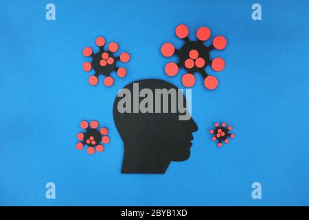 Mental health depression and anxiety concept. Male silhouette human head profile with coronavirus in blue background. Stock Photo