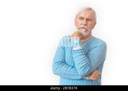 Freestyle. Senior bearded man in sweater standing isolated on white touching chin pensive Stock Photo