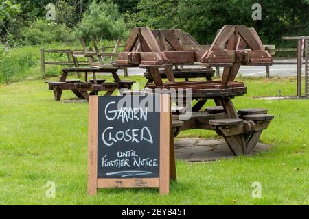 Pub beer garden closed during the 2020 coronavirus covid-19 pandemic with tables piled up, UK Stock Photo