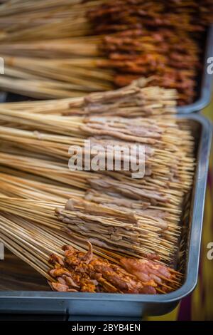 Portions of raw meat, vegetables and seafood on wooden sticks, ready to be grilled on the street in the Muslim Quarter, Xian town, China Stock Photo