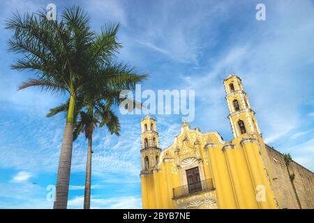 Colonial church 'SAN Juan Bautista' in the colonial center of Merida during last sun on blue sky, Yucatan, Mexico Stock Photo