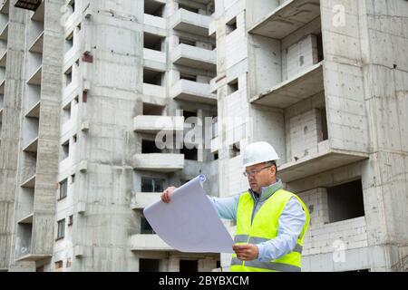 Senior Engineer Working on Building Site Stock Photo