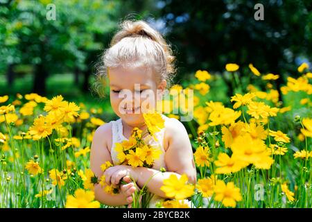 a little white-haired girl in yellow flowers Stock Photo