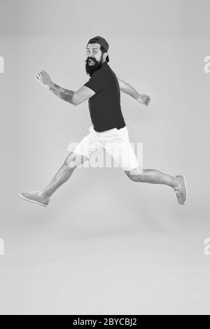 Always in motion. Enjoying active lifestyle. Happy guy jumping. Active bearded man in motion yellow background. Active and energetic hipster. Energy charge. Healthy guy feeling good. Inspired concept. Stock Photo