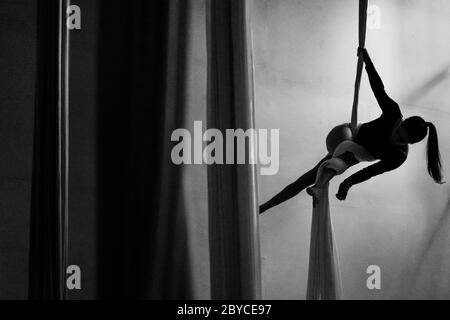 A Colombian aerial dancer performs on aerial silks during a training session in a gym in Medellín, Colombia. Stock Photo