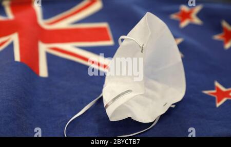 Crumpled face mask after New Zealand successfully beats the covid-19 corona virus allowing public life to return to normal. New Zealand flag. Success Stock Photo