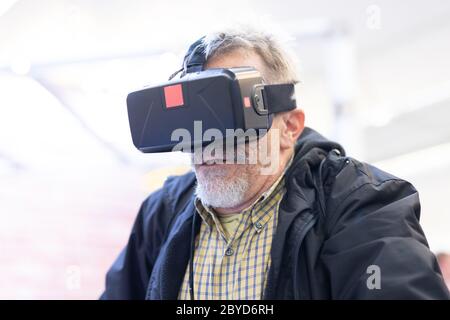 Senior man wearing virtual reality headset glasses. Virtual reality presentation Stock Photo