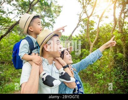 happy family hiking through the forest and teaching child to know nature Stock Photo