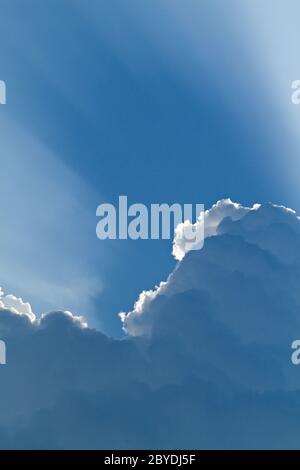 sunlight shining through layers of clouds Stock Photo