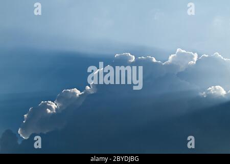 sunlight shining through layers of clouds Stock Photo
