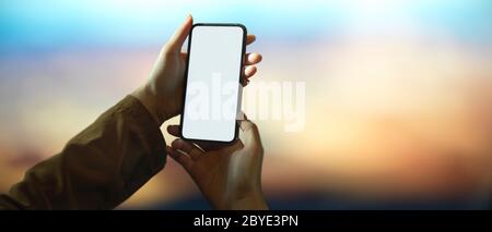 Close up view of female content creator looking image on camera while sitting at wooden worktable Stock Photo