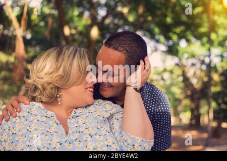 Lovely couple kissing and holding hands walking in the wood Stock Photo