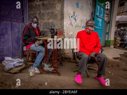 Nairobi, Kenya. 09th June, 2020. Two men are seen wearing facemasks seated outside a shop with a sewing machine amid coronavirus pandemic.Residents of Nairobi have decided to move on with their business as usual despite the economy lockdown and restrictions of movements in and out of the Country including restrictions of movements outside Nairobi, Mombasa and other Counties. Credit: SOPA Images Limited/Alamy Live News Stock Photo