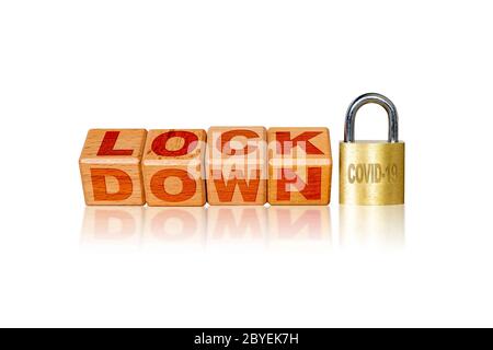 Lockdown due to Covid-19 coronavirus outbreak pandemic. Concept of self isolation or quarantine message engraved on wooden blocks on white background. Stock Photo