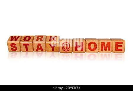 Work at Home, Stay at Home due to Covid-19 coronavirus outbreak pandemic. Concept of self isolation or quarantine message engraved on wooden blocks is Stock Photo