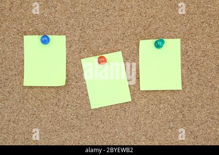three yellow memo sticker on notice cork board Stock Photo