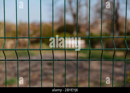 Steel grill fence with blurred wire background. Stock Photo