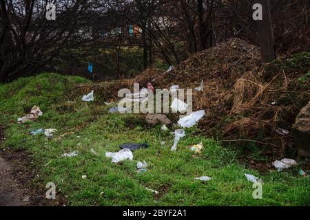 Dneprorudnoe/Ukraine - January 29 2020:Disposable bags are scattered on the ground. Garbage in the forest. The problem of plastic waste pollution. Stock Photo