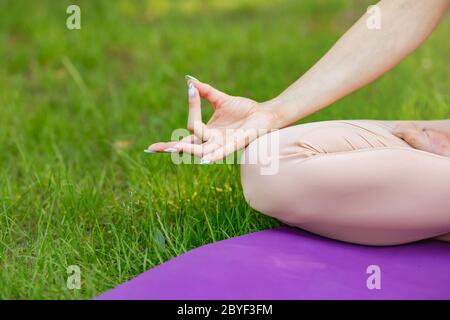 Women sitting in lotus pose, meditating or praying. Healthy lifestyle Stock Photo