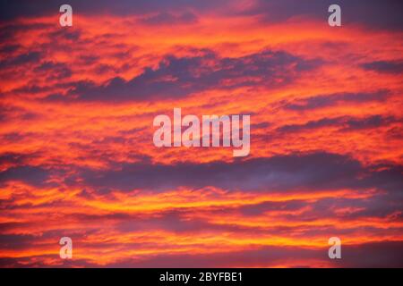 Dramatic sunset vivid red and orange yellow colored clouds Stock Photo