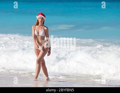 woman in the New Year's cap walks on a beach Stock Photo