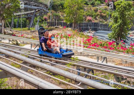 Vietnam, Nha Trang, 24.05.2020: People in medical masks after an epidemic of coronovirus on Rail downhill on a trolley, Point of view during a ride on