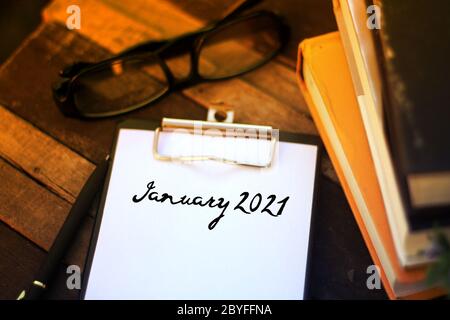 January 2021 wording written on white memo pad with reading concept Stock Photo