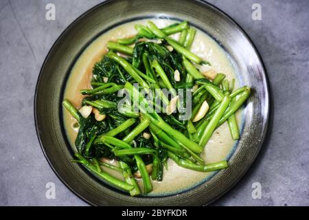 Water spinach stir fry on ceramic plate Stock Photo