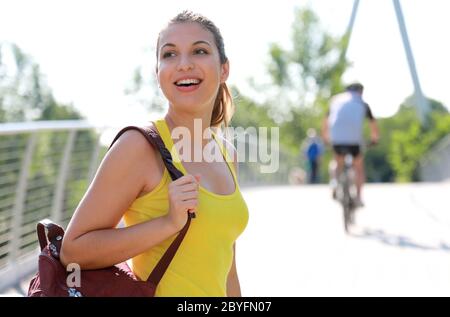 Happy cheerful female hiker walks on a path in natural park Stock Photo