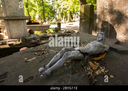 Jesus figure with broken arm on a grave. Stock Photo