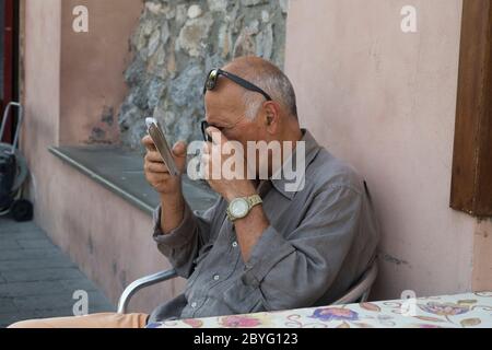 A man needs magnifying glasses to read. Stock Photo