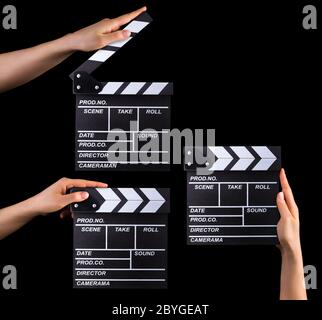 Set of film clapper boards and human hands isolated on black background Stock Photo