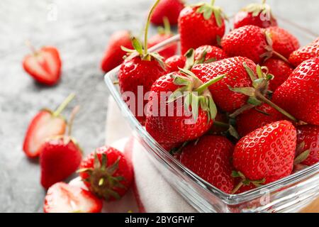 Composition with bowl of tasty strawberry on gray table. Summer berry Stock Photo