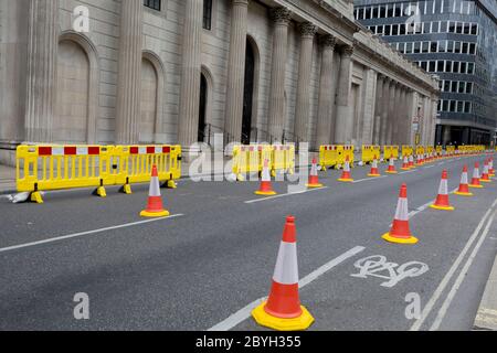 As the UK's Conornavirus pandemic lockdown continues, but with travel restrictions and social distancing rules starting to ease after three months of closures and isolation, yellow barriers and social distance cones have narrowed the road in favour of wider pedestrian pavements outside the Bank of England on a deserted Threadneedle Street, on 9th June 2020, in London, England. Stock Photo