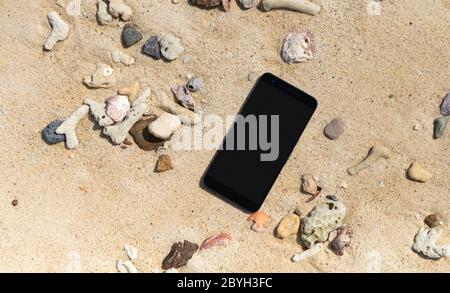 Smart phone with empty screen on tropical sand beach Stock Photo