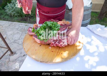 Italy. Beef steaks on a cutting board. The grill chef takes a beef steak to put it on the barbeque grill. Stock Photo