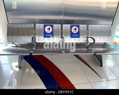 Dubai / UAE - June 9, 2020: 'Don't sit , Stop Covid-19' sticker sign on seats in metro station in english and arabic languages. Social distancing in 2 Stock Photo