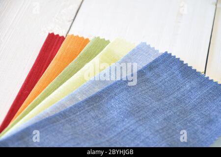 Several fabrics with different colors on a white wooden table Stock Photo