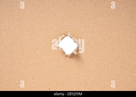 Ripped hole in cardboard on white background Stock Photo
