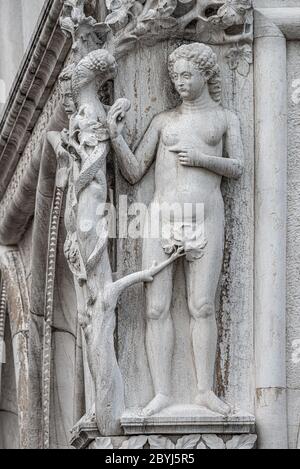 Ancient aged sculpture of beautiful Eva with apple from Bible story at Doge Palace in Venice, Italy Stock Photo