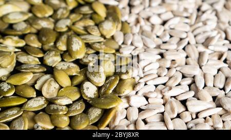 Top view of different seeds as a background. Two parts of sunflower and pumpkin seeds. Healthy food. Seeds texture Stock Photo