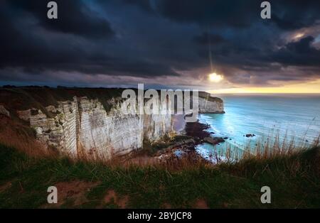 sunshine and storm sky over cliffs in ocean Stock Photo